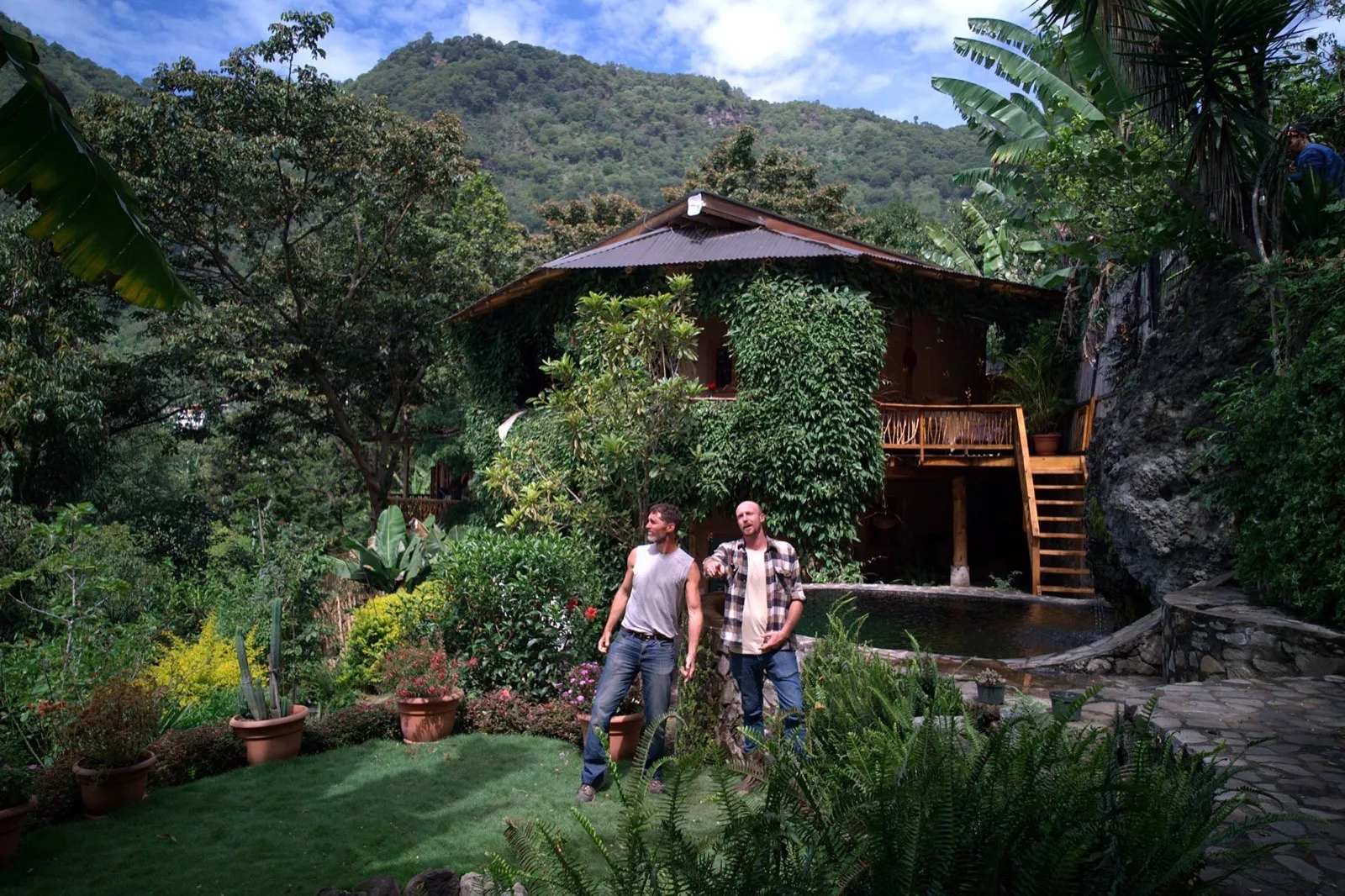 Casa de Surya from the garden: the vine-covered house above its spring-fed pool