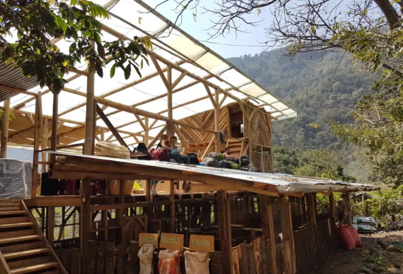 The timber frame of the farm building under construction at Granja Tz'ikin, with the valley behind