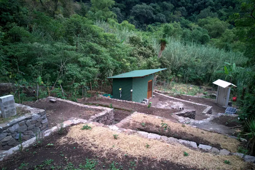 Dry-stone retaining walls going in across the slope at Granja Tz'ikin, the beds behind them still bare earth